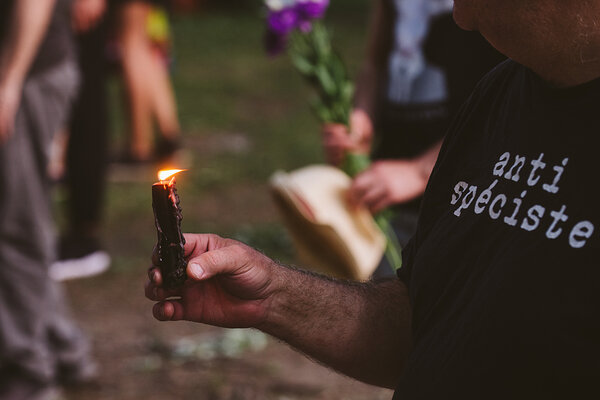 An anti-speciesist activist holds a black candle during a Montreal candlelight vigil for Regan Russell. Saint Louis Square, Montreal, Quebec, Canada, 2020. Victoria de Martigny / We Animals